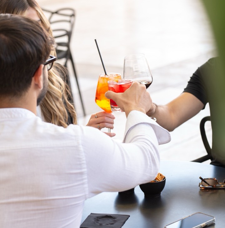 People enjoying colorful cocktails in social dining atmosphere
