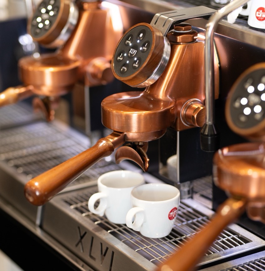 Professional copper espresso machine with white coffee cups
